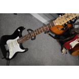 A Gear 4 Music 12 string electric guitar , having 'stratocaster' shaped body in black with white