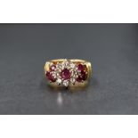 An 18ct gold ruby & diamond cluster ring having a central ruby, approx 0.25ct, within a surround