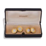 BULGARI: A PAIR OF STAINLESS STEEL AND GOLD CUFFLINKS • Polished disks engraved 'Bvlgari Bvlgari' •