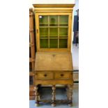 An early 20thC cream shabby chic painted bureau cabinet, the upper section with a glazed door,
