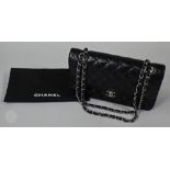 Chanel - A classic black quilted leather hand bag, with burgundy leather interior, white metal