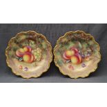 A pair of Royal Worcester porcelain plates of circular form, decorated with peaches,