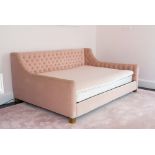 A PINK UPHOLSTERED DOUBLE BED
