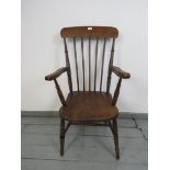 A late 19th Century elm and beech Windsor chair, with dished seat. Raised on turned supports
