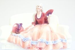 Porcelain figure of a seated lady holding a fan, with green factory mark B78