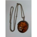 A silver necklace having a Baltic amber style cabochon pendant housed in a Garrard jewellery box.