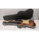 A Fender Stratocaster electric six string guitar with a metallic orange finish, having 'Super
