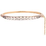An Antique Victorian gold diamond hinged bangle, late 19th century, claw set with a row of graduated