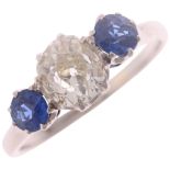 A platinum three stone sapphire and diamond ring, circa 1920, claw set with 1.00ct elongated old