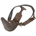 An Antique Omani ceremonial Jambiya dagger with rhino horn handle, silver and leather scabbard,