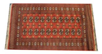 TURKOMAN BOKHARA RUG with two rows each of ten guls on a wine red field, the narrow principal border