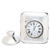 A pocket watch in a silver case and a silver inkwell