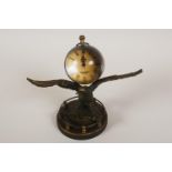 A brass and glass desk clock in the form of an eagle with ball clock on its back, 14cm high