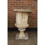 A reconstituted stone garden urn with moulded decoration of classical maidens, 87cm high