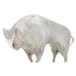 A cast silver figure of a stylized bull.