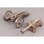 A brass table cannon in the form of a 17th Century cannon 16cm and 1 other with wooden carriage