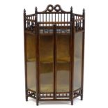 An Arts & Crafts glazed cabinet by Liberty & Co, surmounted by turned finials with pierced