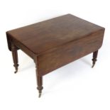 A 19thC Gillows style table raised on turned tapering legs terminating in brass caps and castors.