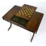 An early 19thC rosewood games table in the manner of Gillows, the top having a central sliding