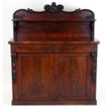 A Victorian mahogany chiffonier with a shaped and carved upstand supporting a shelf, the base having