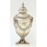 A silver sucrier of urn form with acorn pedestal base, rams heard and swag detail and acorn formed