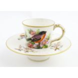 A 19thC Royal Worcester Trembleuse cup and saucer decorated with birds and flowering branches.