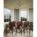 A SET OF SIX GEORGE III ARMORIAL HALL CHAIRS
