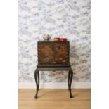 A JAPANESE BLACK LACQUER AND PARCEL-GILT CABINET ON STAND