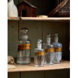 A SELECTION OF FOUR GLASS APOTHECARY BOTTLES WITH ROUNDED STOPPERS