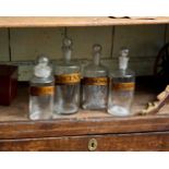 FOUR GLASS APOTHECARY BOTTLES WITH ROUNDED STOPPERS