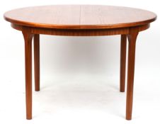 A mid 20th century teak circular extending dining table by Mackintosh raised on turned tapering