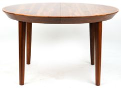 A mid 20th century Danish rosewood circular extending dining table with two extra leaves, raised