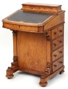 A mid Victorian burr walnut Davenport desk, the hinged writing surface above four drawers, raised on