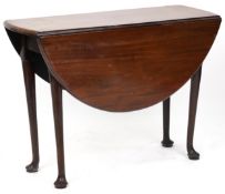 A late George III mahogany drop flap dining table raised on turned tapering legs and pad feet,