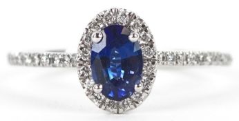 A platinum sapphire and diamond cluster ring with diamond set shoulders, total diamond weight 0.18