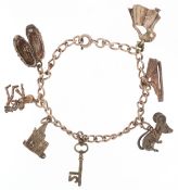 A silver charm bracelet with mostly silver charms including a skeleton, harp and a church, 23.8g.