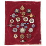 A collection of Royal Army Service Corps military cap badges and sweetheart brooches, some silver