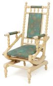 An early 20th century American cream painted rocking chair with upholstered seat and back, 112cm