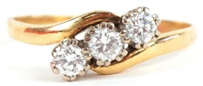 An 18ct gold diamond three stone crossover ring, total diamond weight approximately 0.40 carat, size
