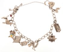 A silver charm bracelet with mostly silver charms, some articulated including a poodle, sewing