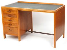 A mid 20th century oak desk, the rectangular top inset with green leatherette writing surface
