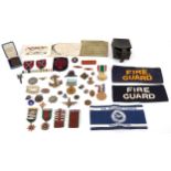 A collection of military interest medals, driving awards, cap badges and commemorative medals