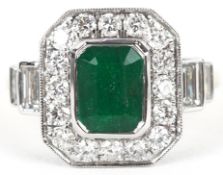 An Art Deco style 18ct yellow and white gold emerald and diamond cluster ring with diamond stepped