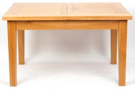 A modern oak rectangular dining table on block legs, 77cm H x 132cm wide x 92cm D.