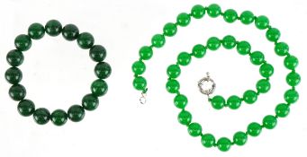 A Chinese green stone bead necklace and bracelet, both test as jade, the necklace 44cm in length,