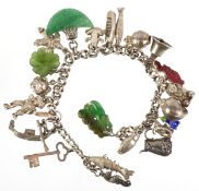 A silver charm bracelet with mostly silver charms including a seahorse, clown and a filigree jug,
