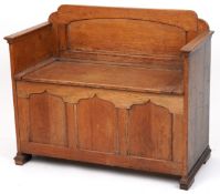 A Victorian oak box seat settle, the hinged seat above a triple panel front, 74cm H x 91cm W x