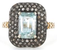 A vintage style silver gilt aquamarine and diamond cluster ring with engraved shoulders, total