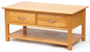 A modern oak coffee table fitted with two drawers above and under tier, 50cm H x 109cm W x 58cm D.