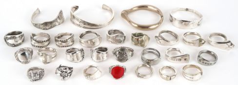 A collection of white metal rings and bangles made from spoon handles, various sizes.